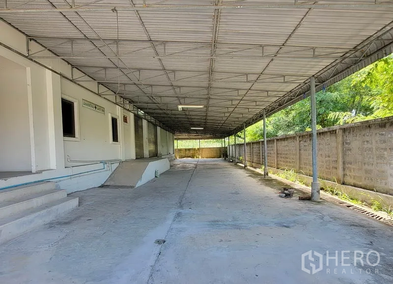 货栈 出租在Sam Phran, Nakhon Pathom - 长条形有顶装卸区，金属屋棚，混凝土车道与多个卷帘门