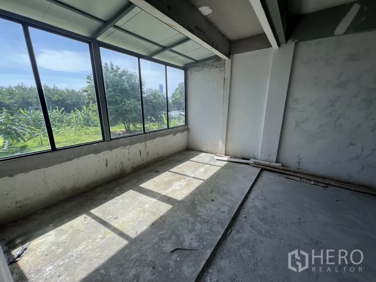 店屋 出售在Suan Luang, Bangkok - 转角房间配全景窗，面向运河绿地与远处天际线。