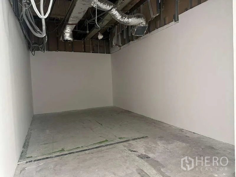 办公空间 出租 - 未装修的31㎡办公室，白色墙面、混凝土地面与外露风管天花，位于伦披尼，临近BTS奇隆。