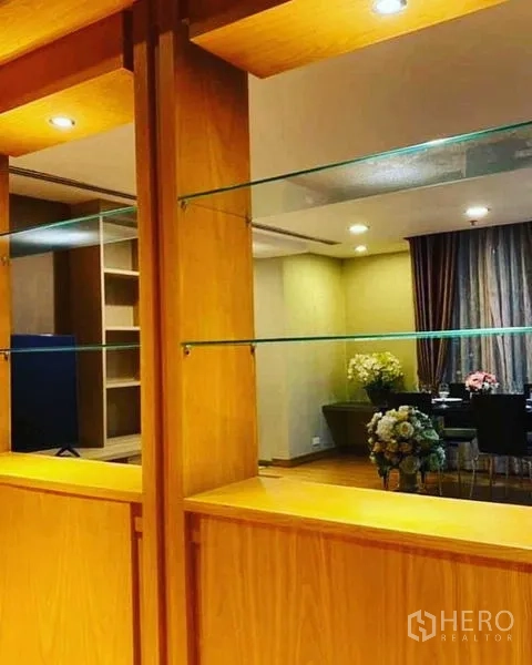 公寓 出租在Watthana, Bangkok - 木质内置柜体，玻璃展示层板与射灯细节特写。