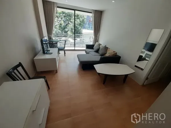 คอนโด ให้เช่าในPathum Wan, Bangkok - ห้องนั่งเล่นสว่าง มีโซฟา โต๊ะทำงาน ชุดวางทีวี และประตูกระจกบานเลื่อนไปยังระเบียง