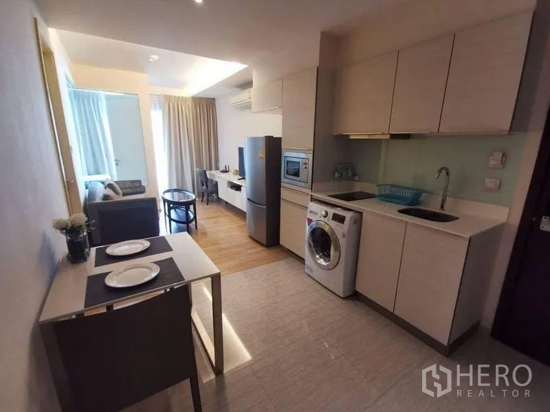 คอนโด ให้เช่าหรือขายในWatthana, Bangkok - เลย์เอาต์ครัวและห้องนั่งเล่น มีตู้สูง ตู้เย็น ชั้นวางทีวี และพื้นไม้