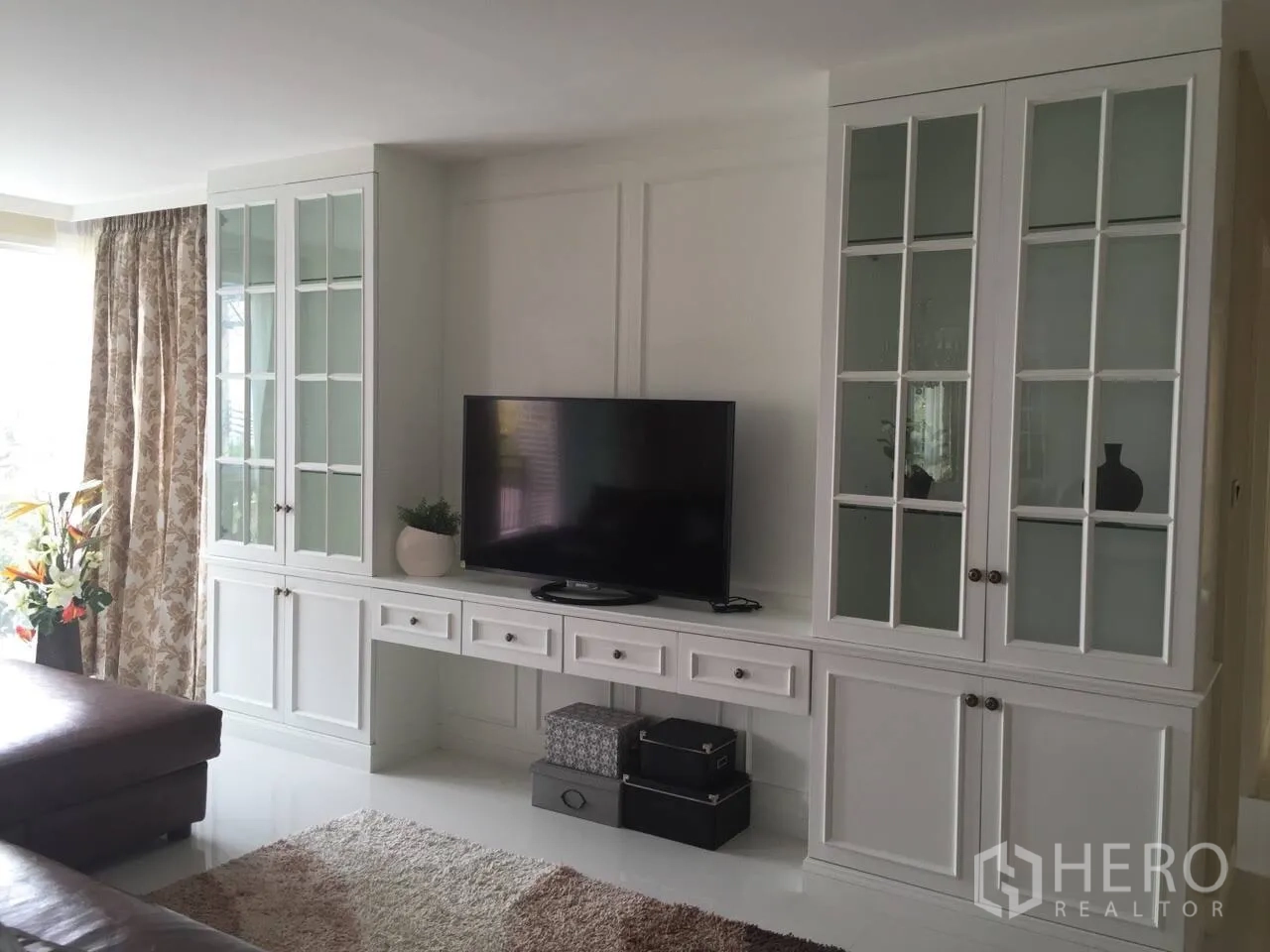 คอนโด ให้เช่าในKhlong Toei, Bangkok - ผนังทีวีบิวท์อินสีขาว ตู้กระจกบานสูง และทีวีจอแบน