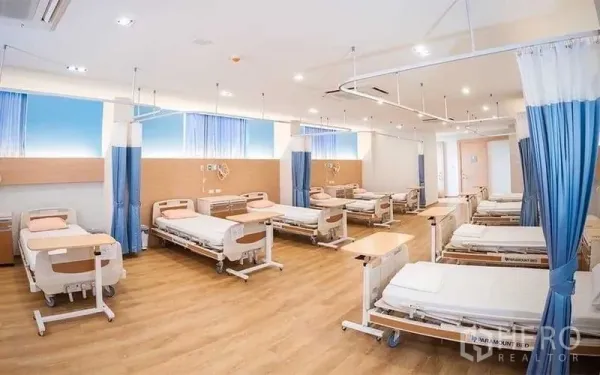 พื้นที่ขายปลีก ให้เช่าในBang Kapi, Bangkok - ห้องสไตล์คลินิกภายใน โปร่งสว่าง มีเตียงหลายเตียง พื้นไม้ และรางม่านสำหรับแบ่งโซน