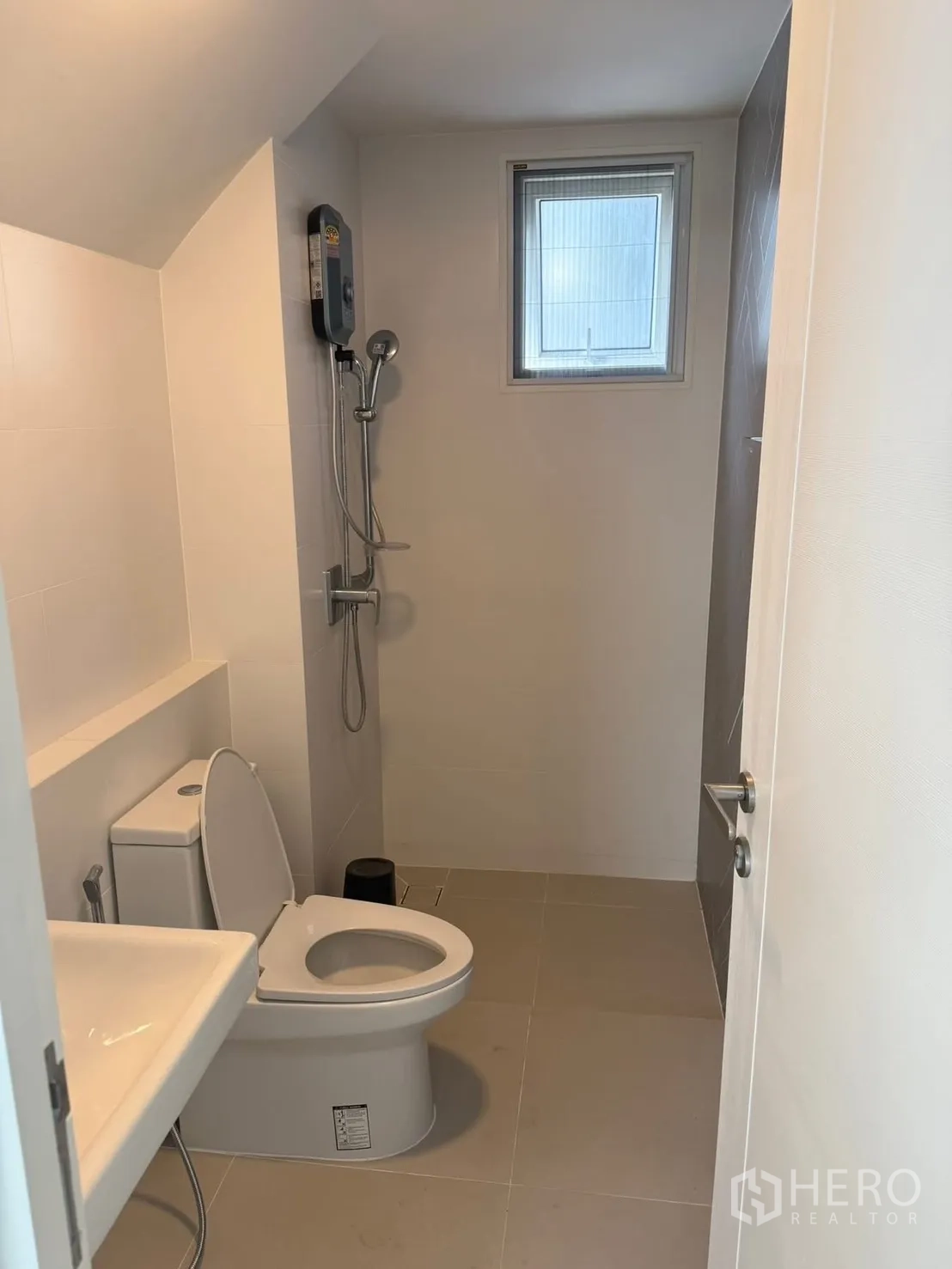 独栋房屋 for rent in Bang Phli, Samut Prakan - 整洁卫浴，含坐便、洗手盆和带热水器的淋浴区与小窗。