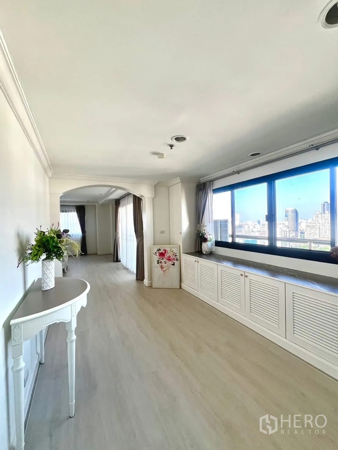 Condominium for rent in Khlong Toei, Bangkok - Long corridor with windows, built-in storage and city views.