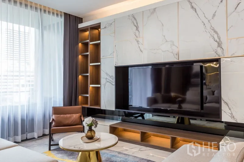 คอนโด ให้เช่าในKhlong Toei, Bangkok - ห้องนั่งเล่นผนังลายหินอ่อน ตู้ชั้นบิลท์อิน และทีวีขนาดใหญ่