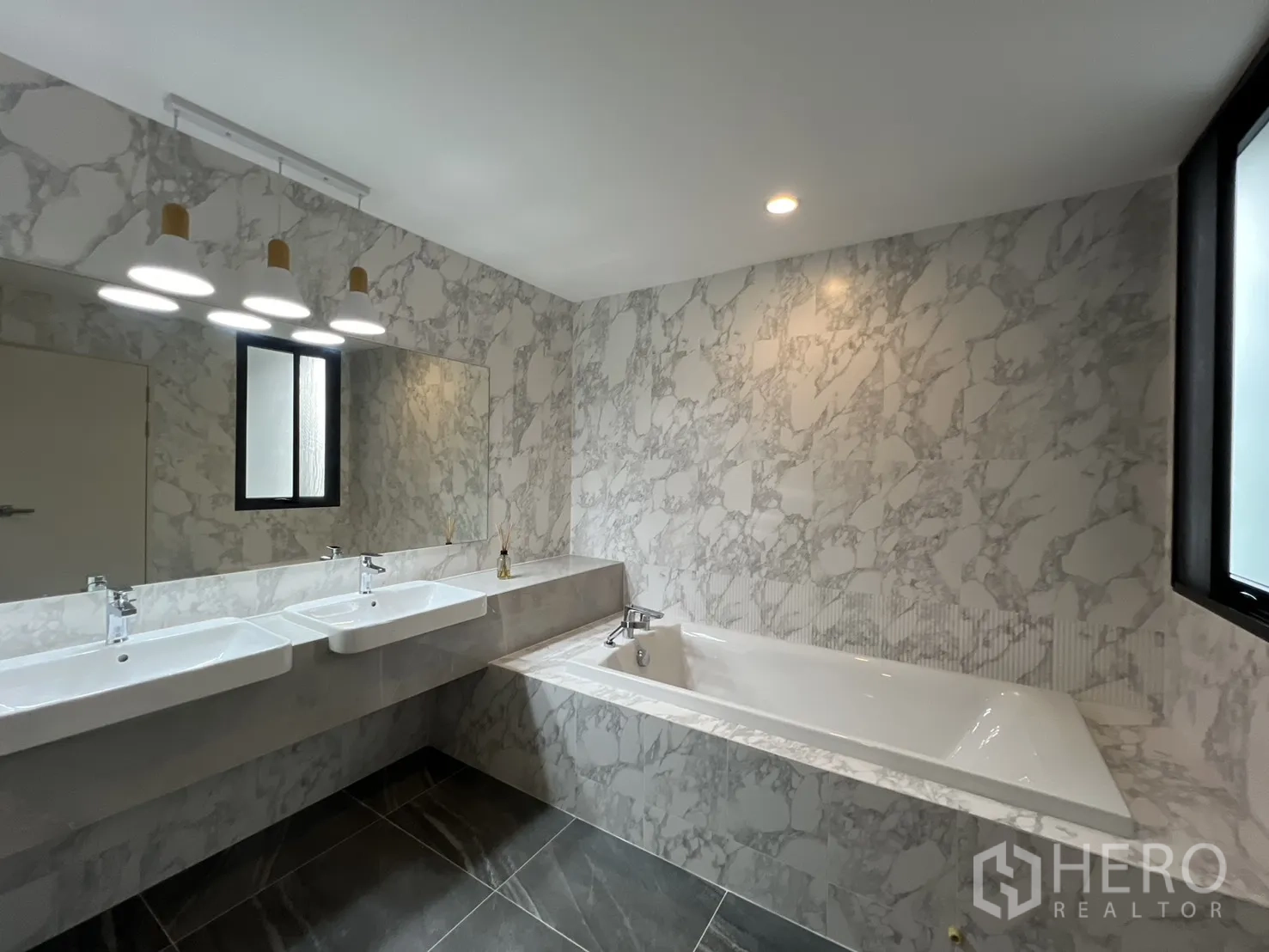 Detached House for rent in Prawet, Bangkok - Marble-clad bathroom with double vanity and soaking tub.
