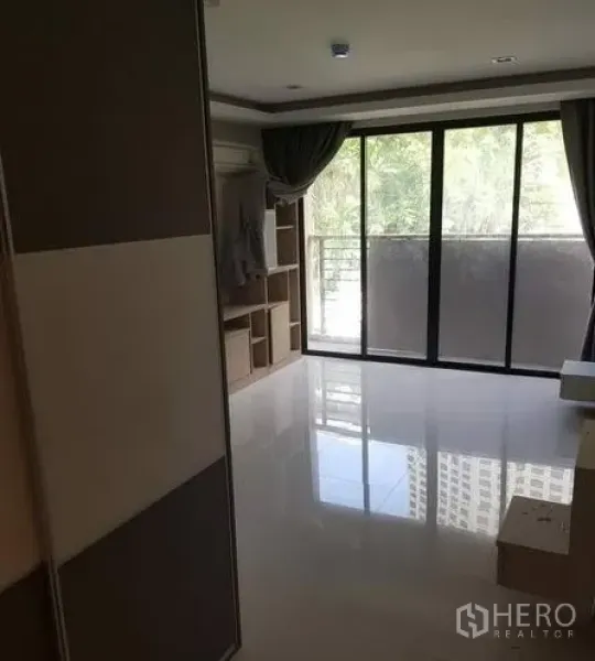 Apartment for rent in Khlong Toei, Bangkok - Bedroom with floor-to-ceiling sliding glass doors opening to a private balcony.