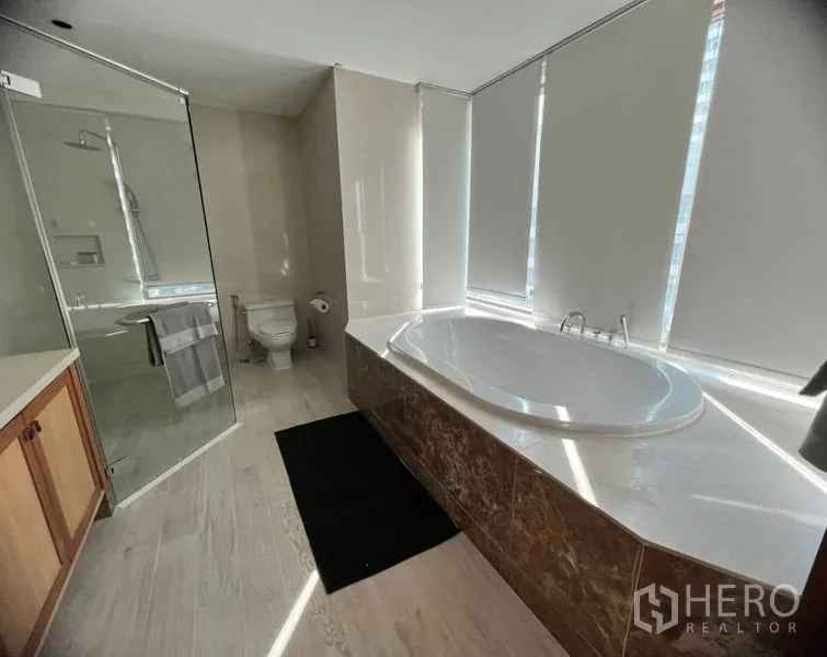 คอนโด ให้เช่าในBangkok - ห้องน้ำมาสเตอร์พร้อมอ่างอาบน้ำทรงรีริมหน้าต่าง และห้องอาบน้ำกระจกแยกส่วน