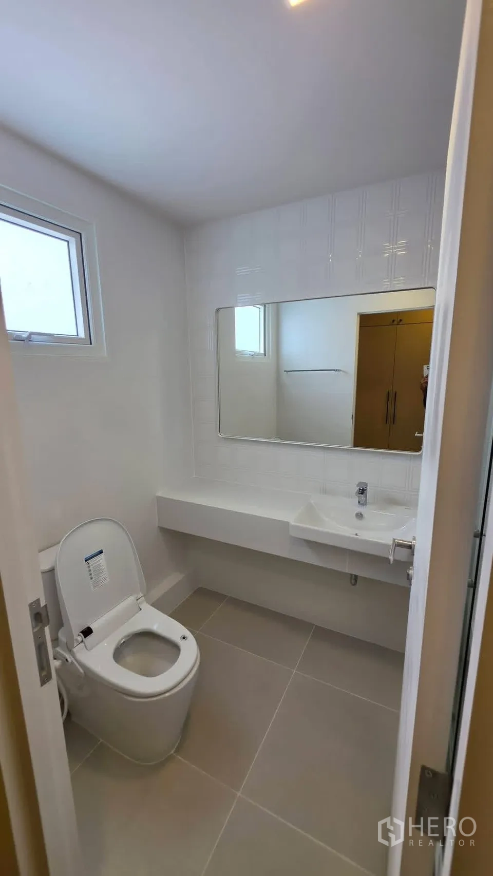 Detached House for rent in Bang Phli, Samut Prakan - Clean bathroom with window, long vanity, mirror, and toilet.