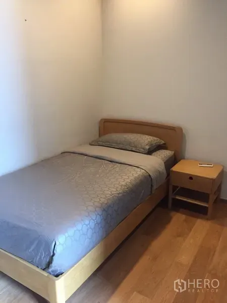 คอนโด ให้เช่าหรือขายในWatthana, Bangkok - ห้องนอนเล็กอบอุ่นพร้อมเตียงเดี่ยว โต๊ะข้างเตียง และพื้นไม้โทนอุ่น