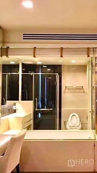 Condominium for rent or sale in Bang Rak, Bangkok - Vanity, bathtub and glass shower with modern fixtures inside the condo bathroom.