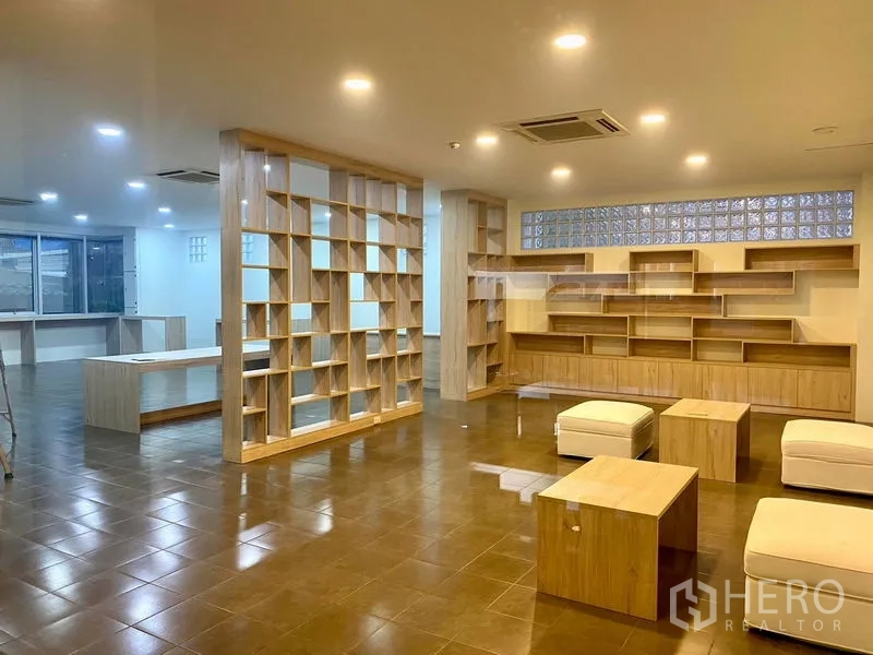 Office Space for rent in Bueng Kum, Bangkok - Open lounge or collaborative area with custom wooden shelving, ottomans, and tiled flooring.