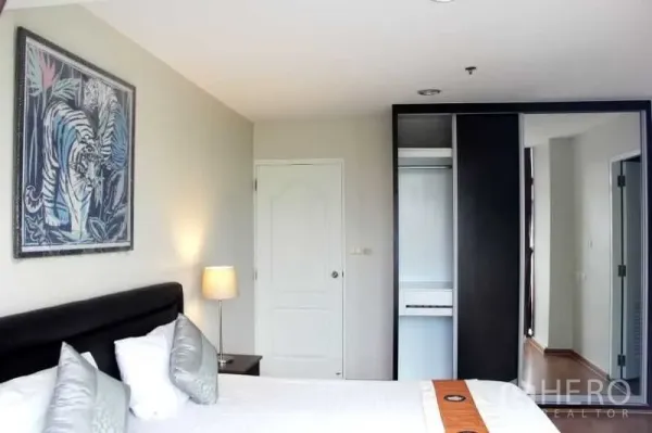 คอนโด ให้เช่าในKhlong Toei, Bangkok - ห้องนอนหลักพร้อมเตียงหัวบุ โคมไฟข้างเตียง และตู้เสื้อผ้าบิลท์อิน