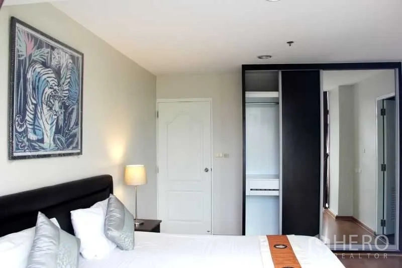 คอนโด ให้เช่าในKhlong Toei, Bangkok - ห้องนอนหลักพร้อมเตียงหัวบุ โคมไฟข้างเตียง และตู้เสื้อผ้าบิลท์อิน