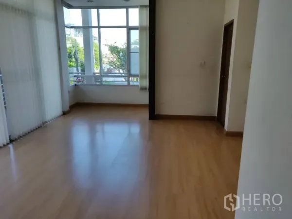 Home Office for rent in Watthana, Bangkok - Upper floor room with corner windows and warm wood flooring.