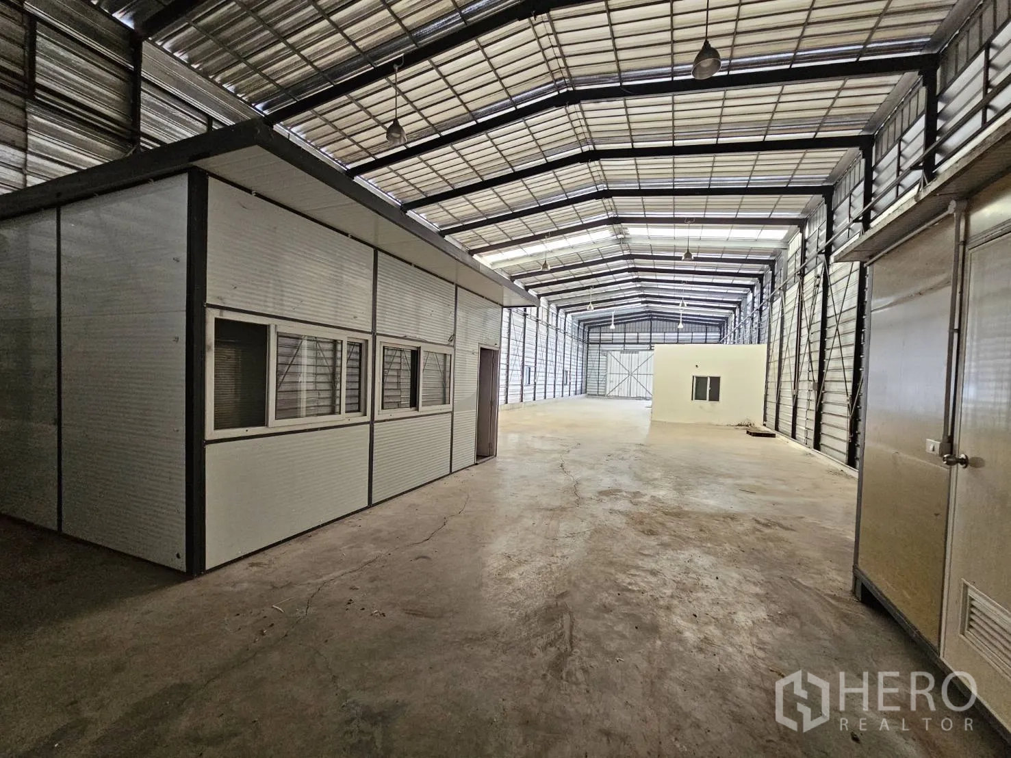 Warehouse for rent in Bang Phli, Samut Prakan - Interior area featuring a modular office partition, overhead industrial lights, and wide aisle space.