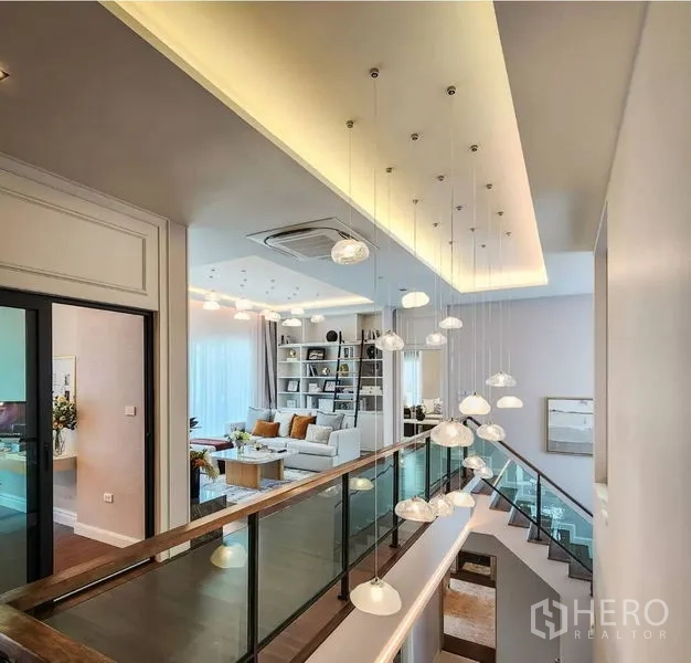 Detached House for sale in Bang Phli, Samut Prakan - Upper hallway with pendant lights and glass railing next to the family lounge.
