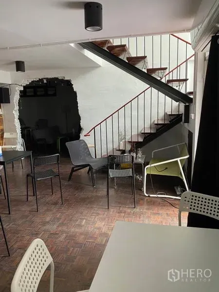 带办公室的家 出租在Pathum Wan, Bangkok - 开放式室内，金属楼梯、白墙与拼木地板上的桌椅。