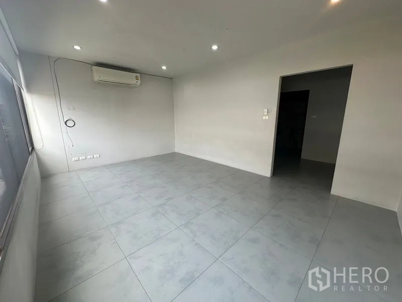 Home Office for rent in Phra Khanong, Bangkok - Clean gray-tiled room with recessed lights and wall-mounted air conditioner.