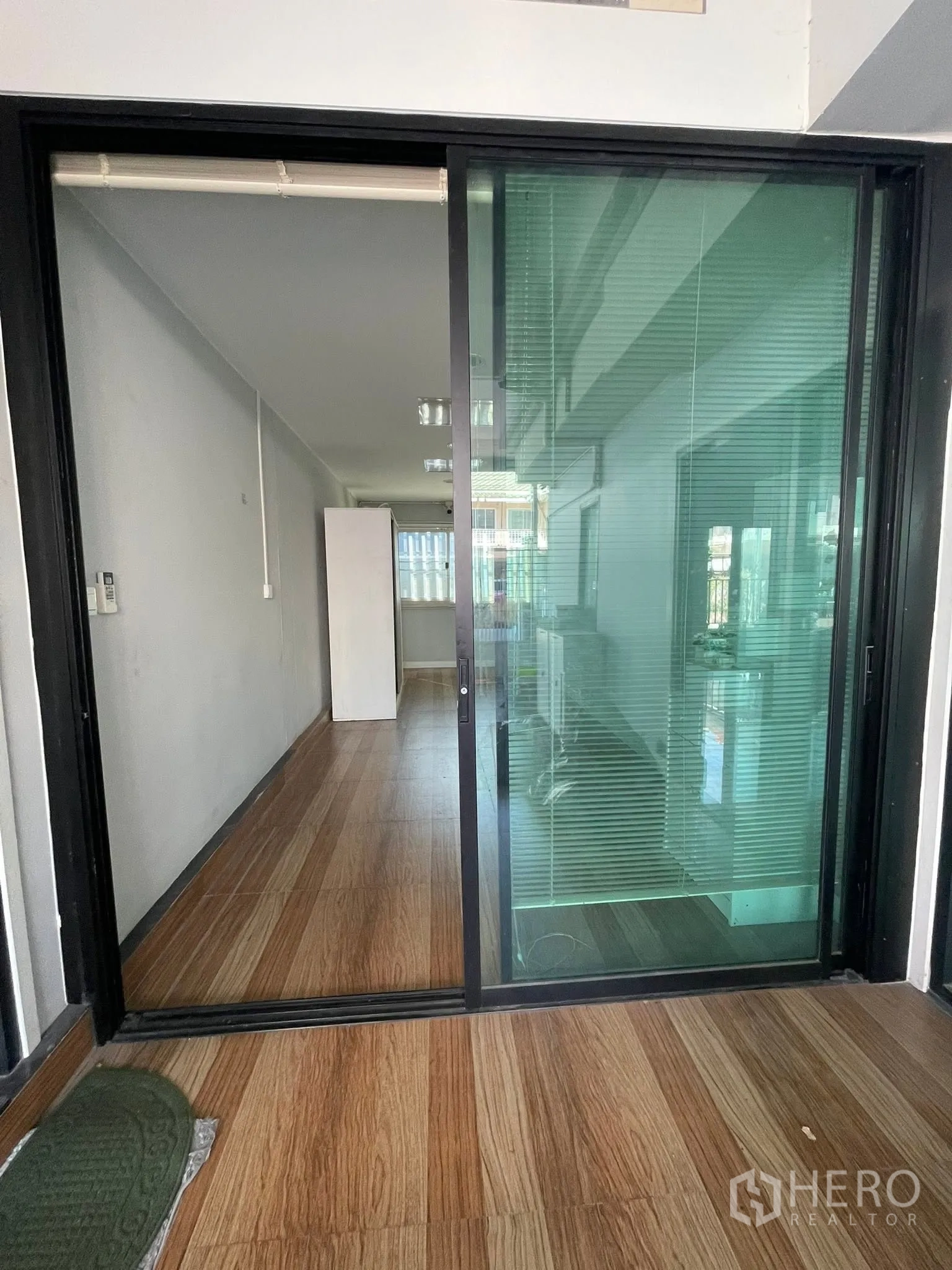 Detached House for rent or sale in Lam Luk Ka, Pathum Thani - Sliding glass partition opening to a narrow room with wood-look floor.