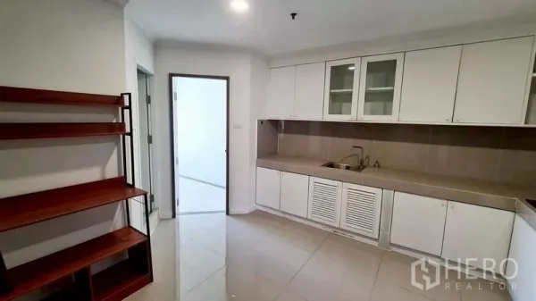 คอนโด ให้เช่าในWatthana, Bangkok - ครัวสว่าง เคาน์เตอร์ยาวสีเบจ ตู้สีขาวและชั้นวาง เปิดสู่พื้นที่อเนกประสงค์