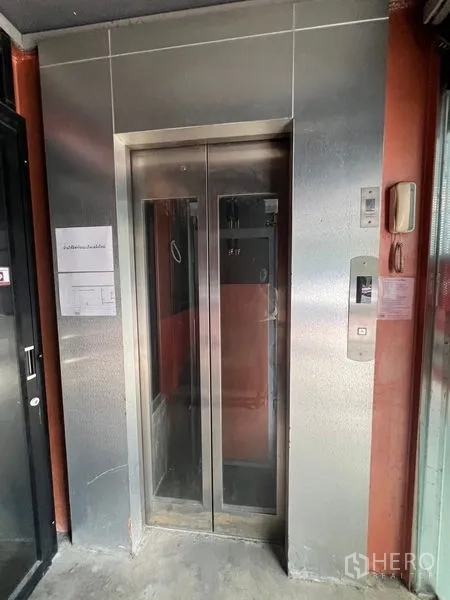 零售空间 出租在Khlong Toei, Bangkok - 商业楼内临铺位的不锈钢乘客电梯。