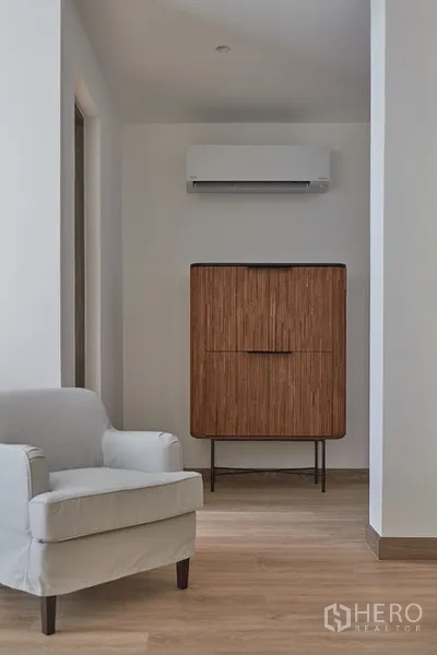 บ้าน ให้เช่าในWatthana, Bangkok - โถงพักผ่อนพร้อมเก้าอี้นวม ตู้ไม้ และเครื่องปรับอากาศ