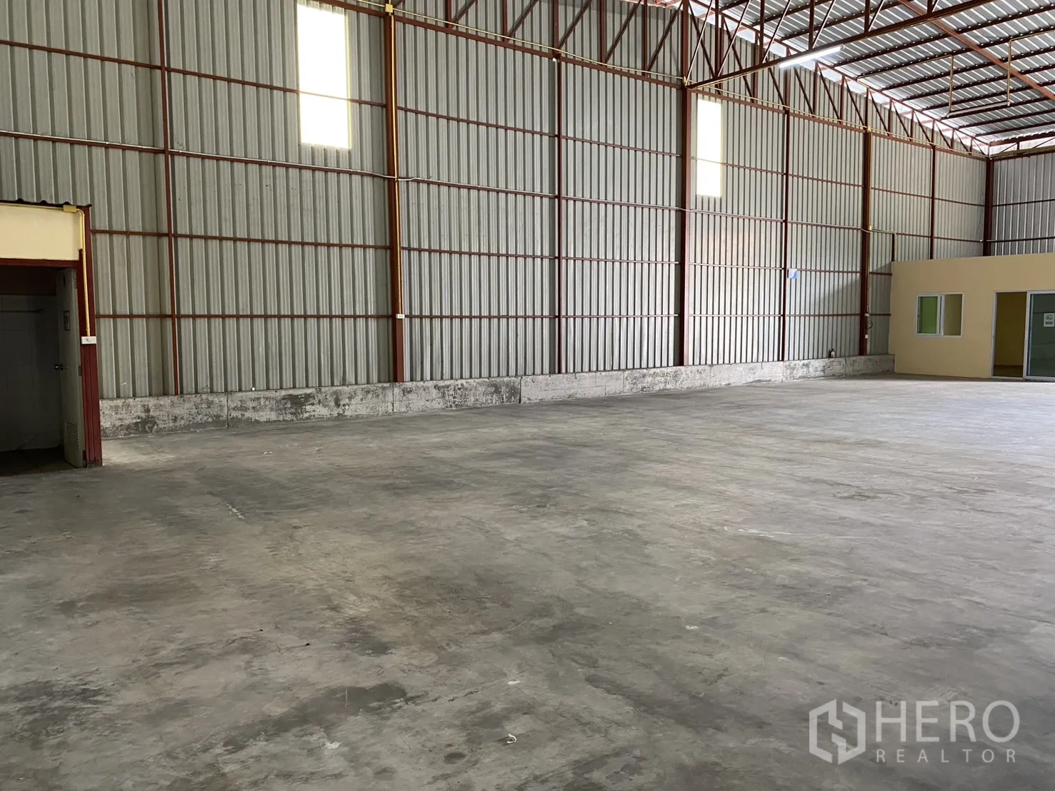 Warehouse for rent in Bueng Kum, Bangkok - Warehouse interior with concrete floor, high steel truss roof and metal wall panels.