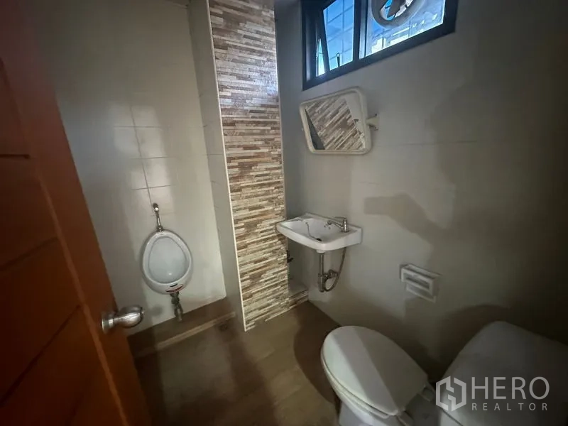 办公空间 出租在Bang Rak, Bangkok - 卫生间配坐便、立式小便池与洗手盆，瓷砖装饰。