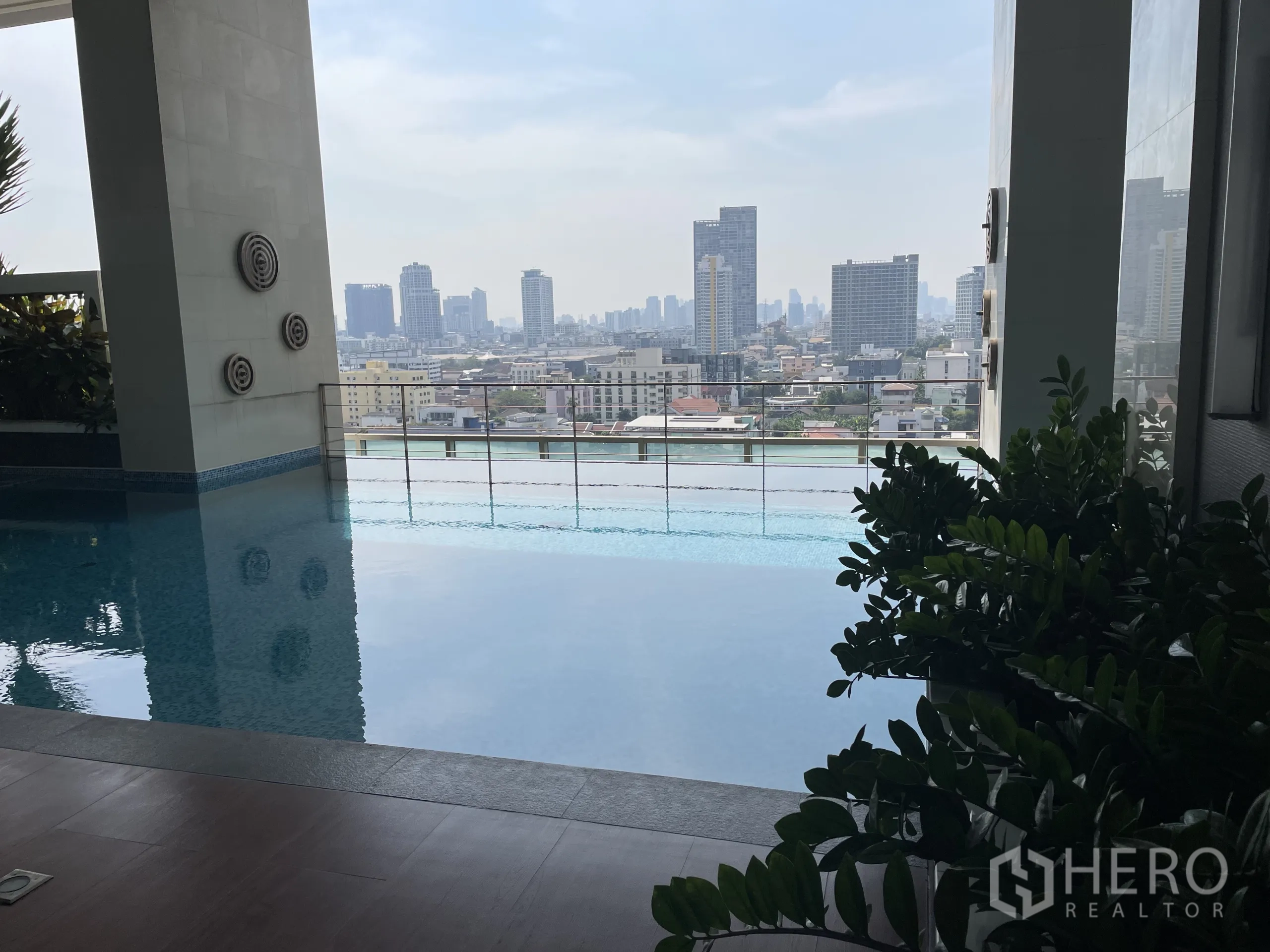 Condominium for sale in Chatuchak, Bangkok - Covered pool overlooking Bangkok city through open terrace frames.