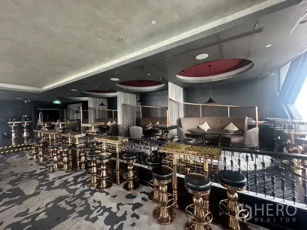 零售空间 出租在Khlong Toei, Bangkok - 抬高的座位区，铜色吧凳与半私密包厢。