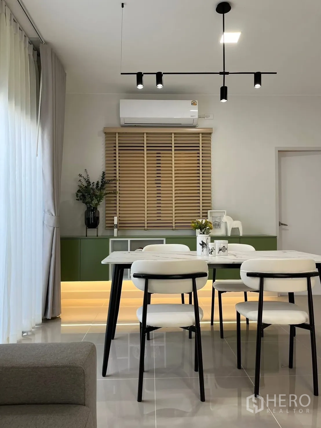 联排别墅 出租在Bang Phli, Samut Prakan - 用餐区，现代吊灯，白色餐椅和带底部灯带的绿色矮柜。