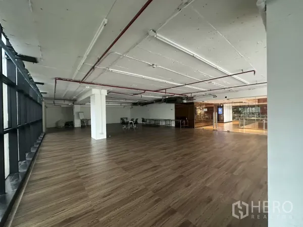 พื้นที่ขายปลีก ให้เช่า - ยูนิตกว้าง โล่ง มองไปยังประตูกระจก เพดานสไตล์อินดัสเทรียล แสงธรรมชาติ