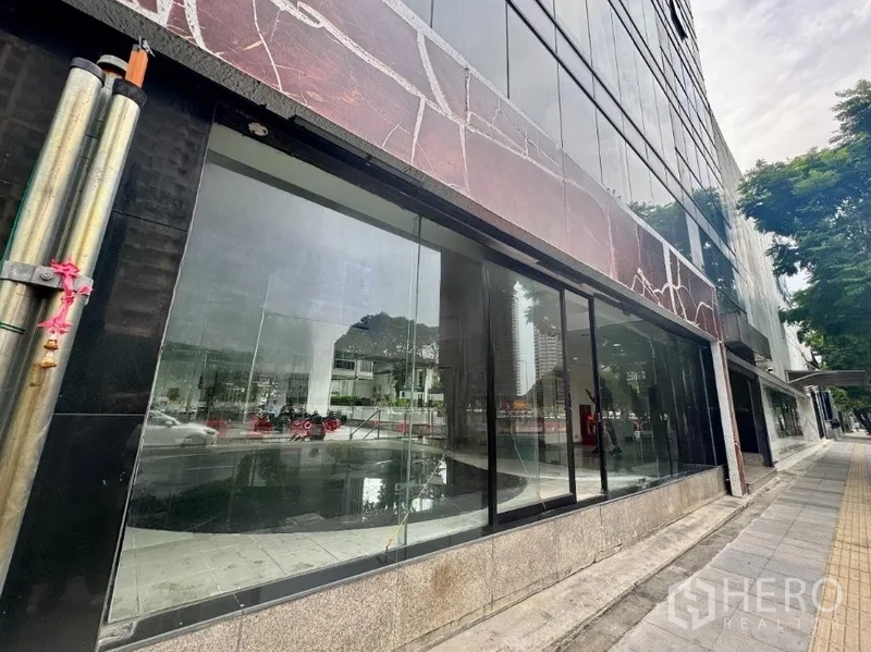 Retail Space for rent in Sathon, Bangkok - Extended glass facade of the retail unit with a wide sidewalk and trees on a city street.
