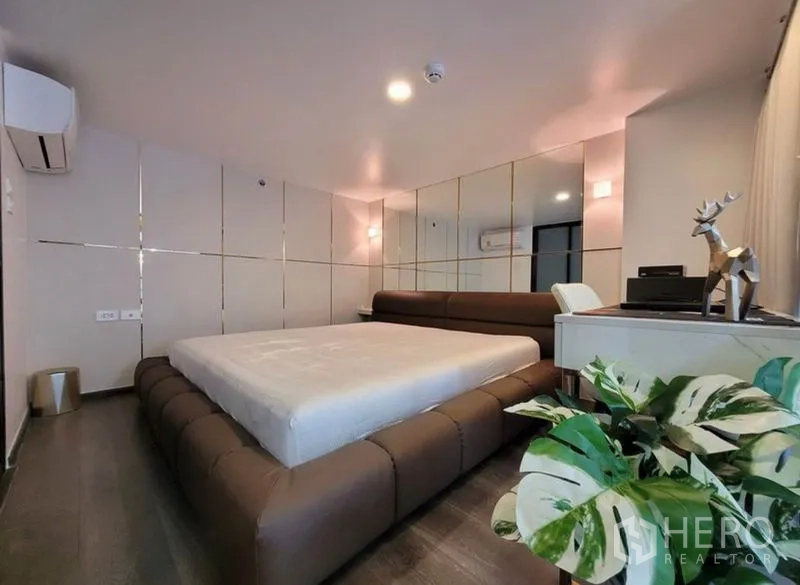 คอนโด ให้เช่าในChatuchak, Bangkok - ห้องนอนสมัยใหม่ เตียงแพลตฟอร์มต่ำ ผนังกระจกเงา โต๊ะทำงาน และเครื่องปรับอากาศ