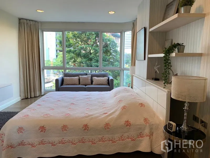 คอนโด ให้เช่าในKhlong Toei, Bangkok - ห้องนอนมาสเตอร์มองไปยังหน้าต่างเต็มบานพร้อมโซฟานั่งเล่น