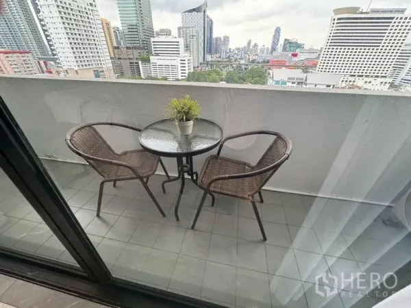 คอนโด ให้เช่าในWatthana, Bangkok - ระเบียงส่วนตัวมีโต๊ะกลมและเก้าอี้หวาย มองเห็นเส้นขอบฟ้าเมือง