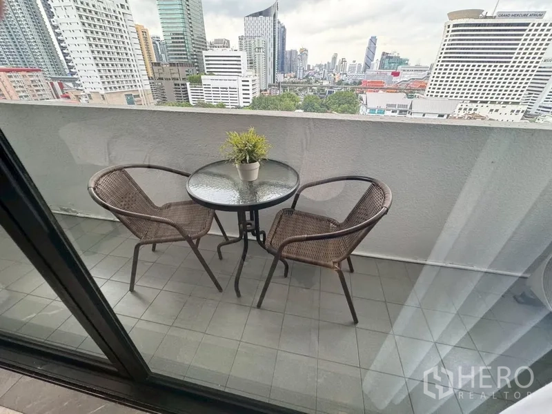 คอนโด ให้เช่าในWatthana, Bangkok - ระเบียงส่วนตัวมีโต๊ะกลมและเก้าอี้หวาย มองเห็นเส้นขอบฟ้าเมือง