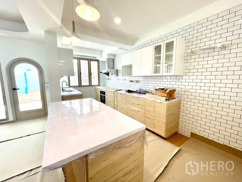 ทาวน์เฮาส์ ให้เช่าในKhlong Toei, Bangkok - ครัวสไตล์โมเดิร์น ผนังกระเบื้องซับเวย์ ตู้ไม้ และเกาะกลางท็อปสีขาว