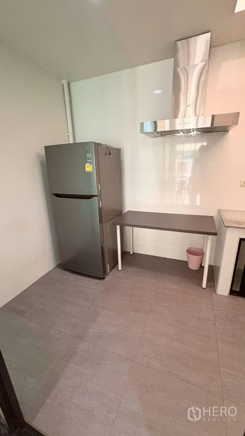 联排别墅 for rent in Phra Khanong, Bangkok - 独立厨房一角，带不锈钢抽油烟机、操作台和冰箱。