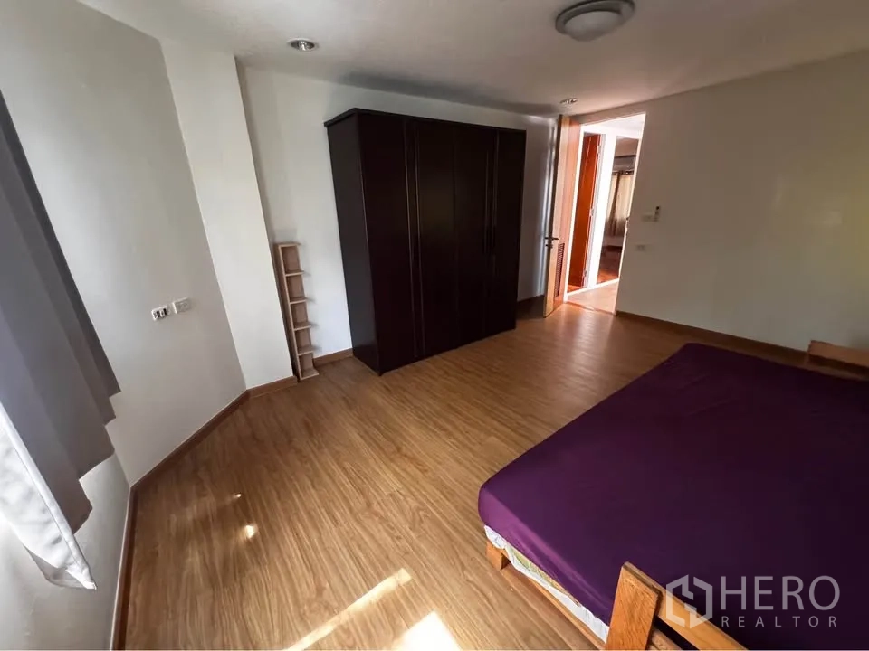 ทาวน์เฮาส์ for rent in Huai Khwang, Bangkok - ห้องนอนพร้อมตู้เสื้อผ้า พื้นไม้ และแสงธรรมชาติ.