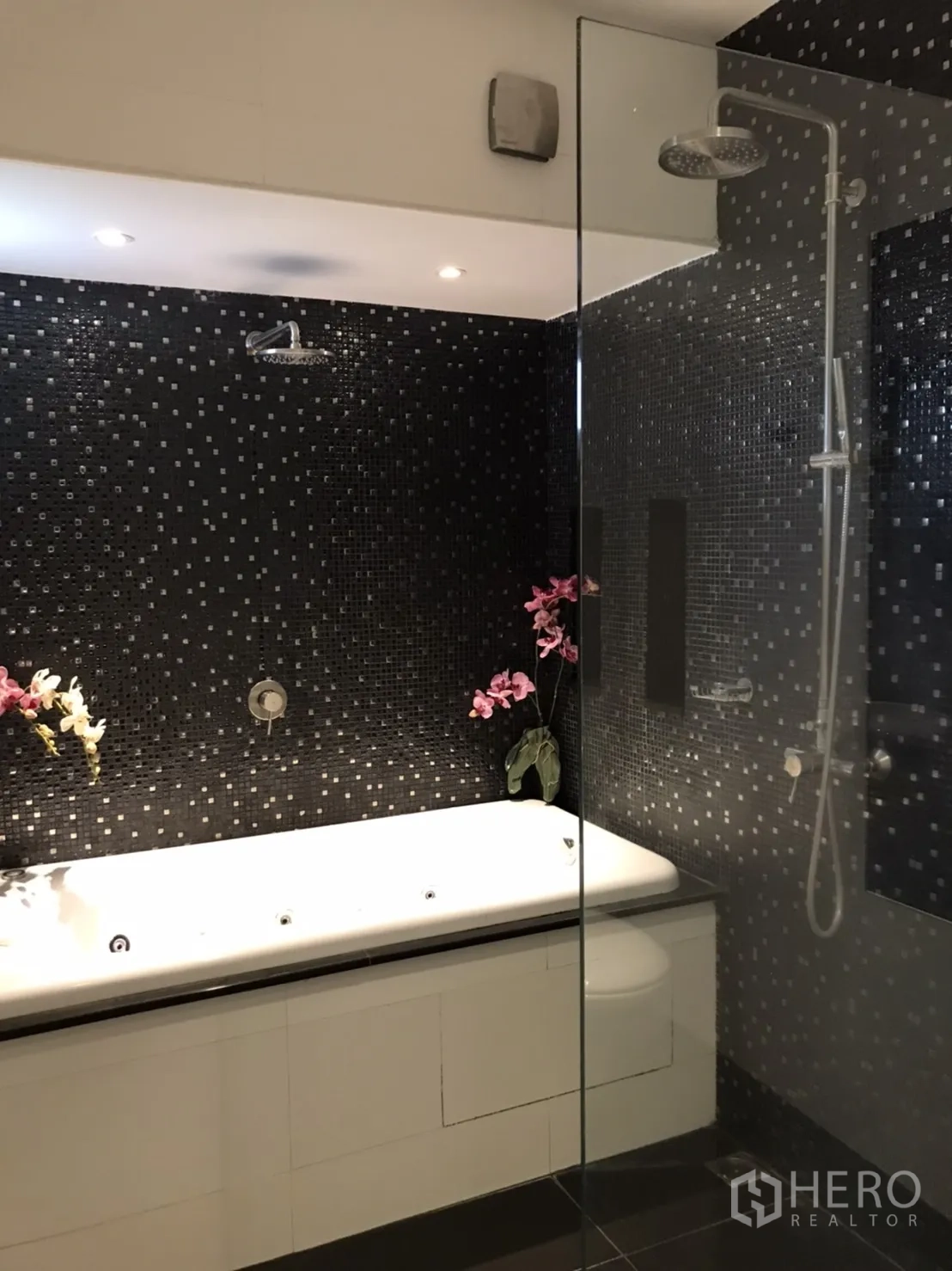 独立式住宅 出租或出售在Saphan Sung, Bangkok - 套内卫浴，黑色马赛克墙、玻璃淋浴与白色浴缸。