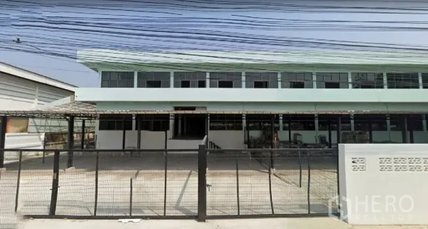 办公空间 出租在Bang Sao Thong, Samut Prakan - 北榄府Bang Sao Thong两层工业风办公楼外立面，带大门与停车区。