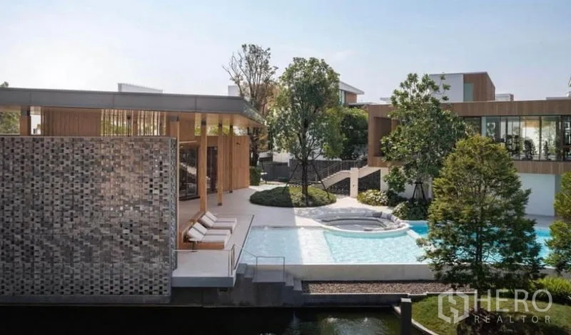 Detached House for rent in Saphan Sung, Bangkok - Resort-style clubhouse with lounge seating and a shallow pool surrounded by trees