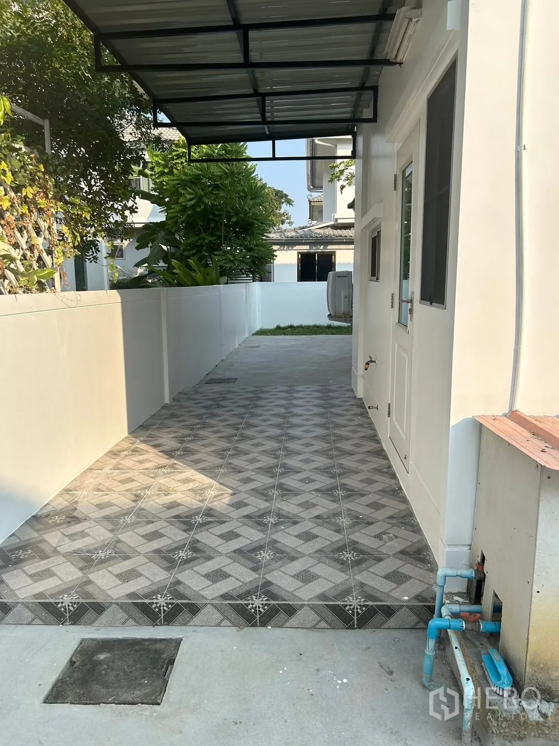 独栋房屋 for rent in Bang Na, Bangkok - 侧院有金属棚顶与花纹地砖，设生活管线区。