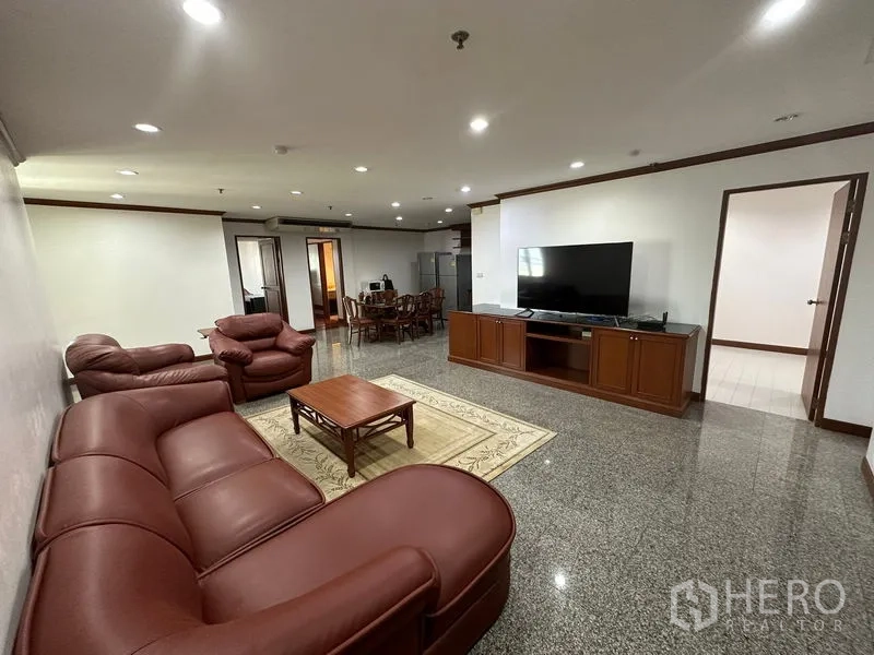 คอนโด ให้เช่าในWatthana, Bangkok - ห้องนั่งเล่นกว้าง โซฟาหนัง ชุดชั้นวางทีวี พื้นหินขัด และพื้นที่รับประทานอาหาร