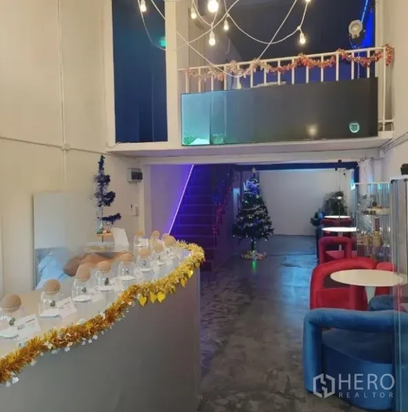 店屋 出租或出售在Khlong Toei, Bangkok - 展示柜台摆放玻璃罐与灯串，旁有座位区并带夹层。