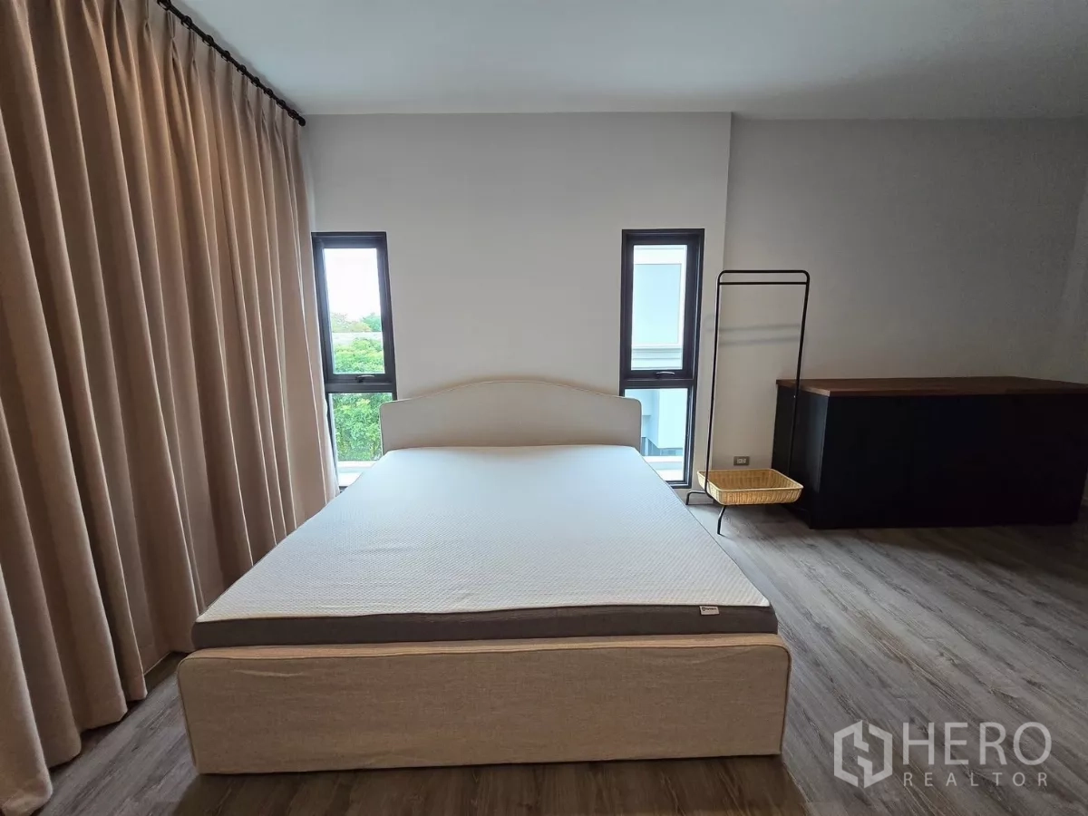 Detached House for rent in Prawet, Bangkok - Bedroom with double bed, tall curtains and narrow vertical windows.